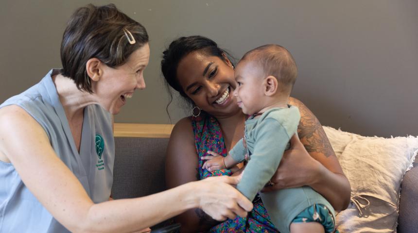 Mother holding child with counsellor